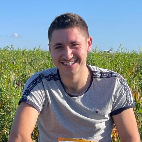 Maxime Rey, cofondateur de Sesame, accroupi dans une parcelle, un dossier à la main